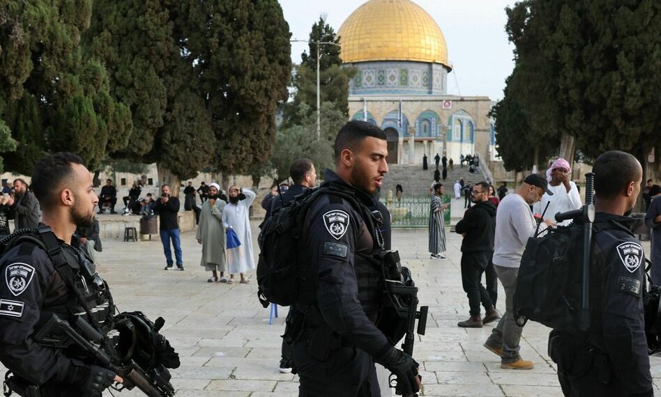 TOPSHOT - Jewish visitors walk protected by Israeli security forces at the Al-Aqsa mosque compound, also known as the Temple Mount complex to Jews, in Jerusalem on April 9, 2023, during the Muslim holy fasting month of Ramadan, also coinciding with the Jewish Passover holiday. (Photo by AHMAD GHARABLI / AFP) (Photo by AHMAD GHARABLI/AFP via Getty Images)